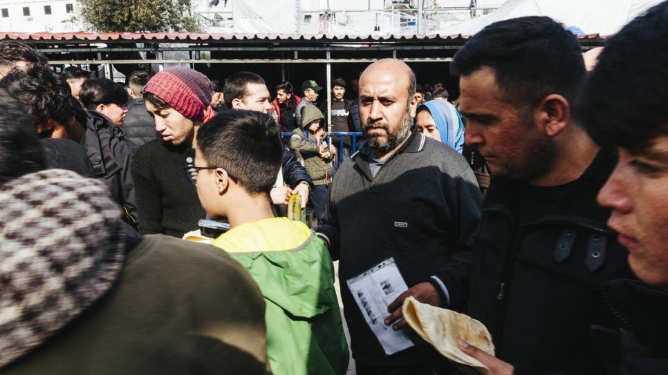 Des demandeurs d'asile et des migrants font la queue au point de distribution de 	nourriture au centre de réception et d'identification surpeuplé de Moria, sur l'île de 	Lesbos. 
