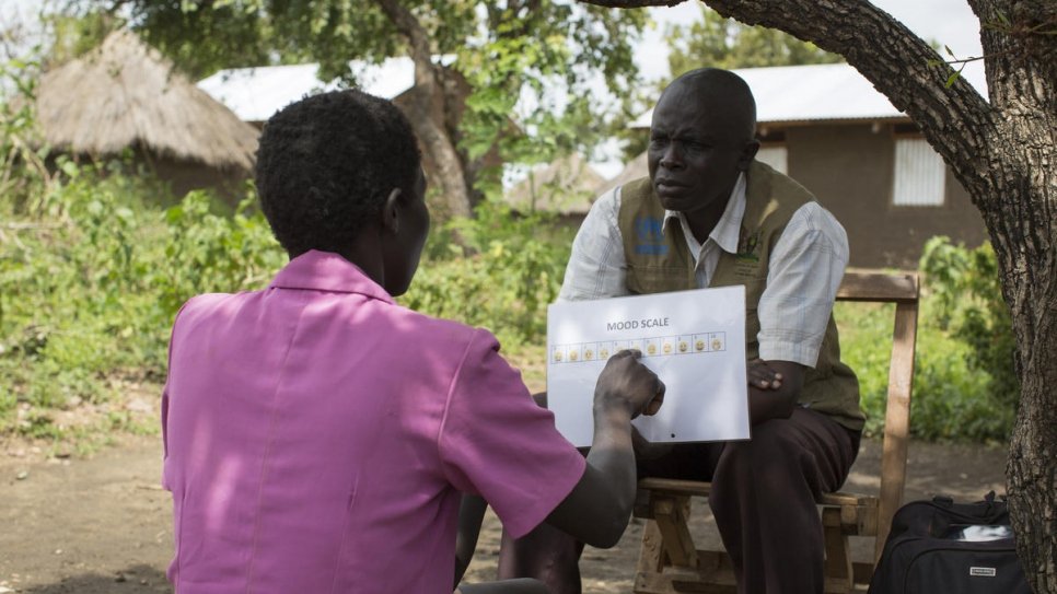Rose*, une réfugiée sud-soudanaise, évalue son état intérieur sur une échelle à pictogrammes durant une consultation de soutien psychosocial au camp de réfugiés de Bidibidi, Ouganda. 