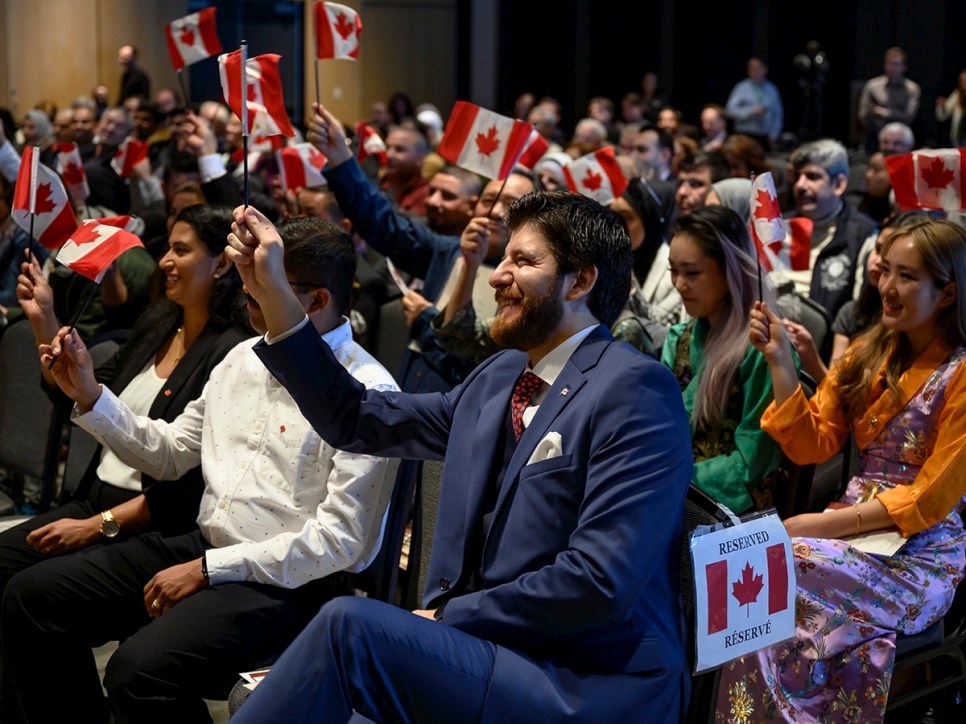 Le mercredi 15 janvier 2020, Tareq Hadhad, un réfugié syrien et le fondateur de Peace by Chocolate, agite un drapeau canadien avec 48 autres nouveaux Canadiens pendant la cérémonie d'octroi de la citoyenneté canadienne au Quai 21 à Halifax (Nouvelle-Ecosse). 