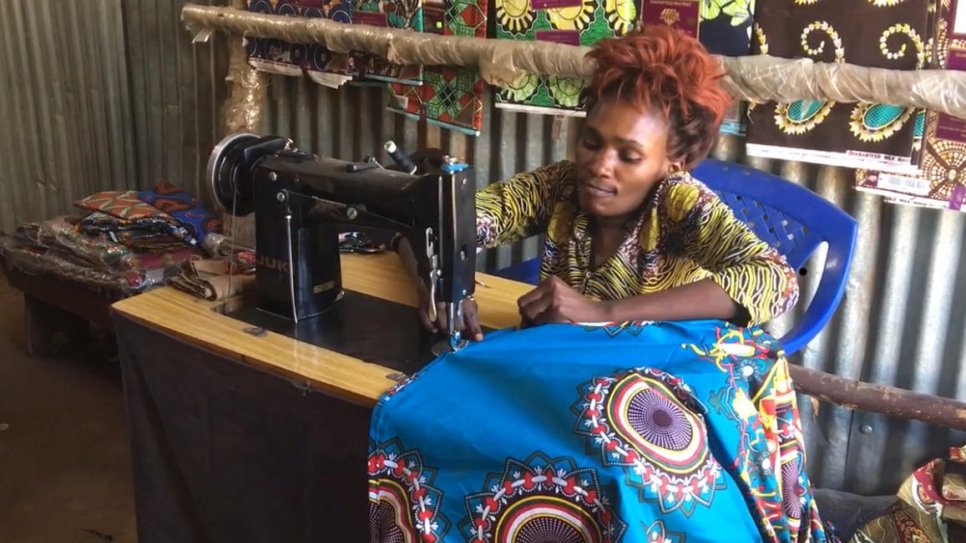 La couturière congolaise Hota Biclere coud une robe dans son atelier qui est aussi sa boutique, au camp de réfugiés de Kakuma, Kenya. 