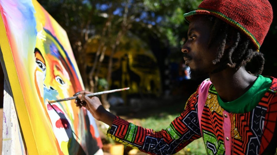 Mike, qui a fui le Burundi en 2015, en train de peindre à l'atelier d'art. 