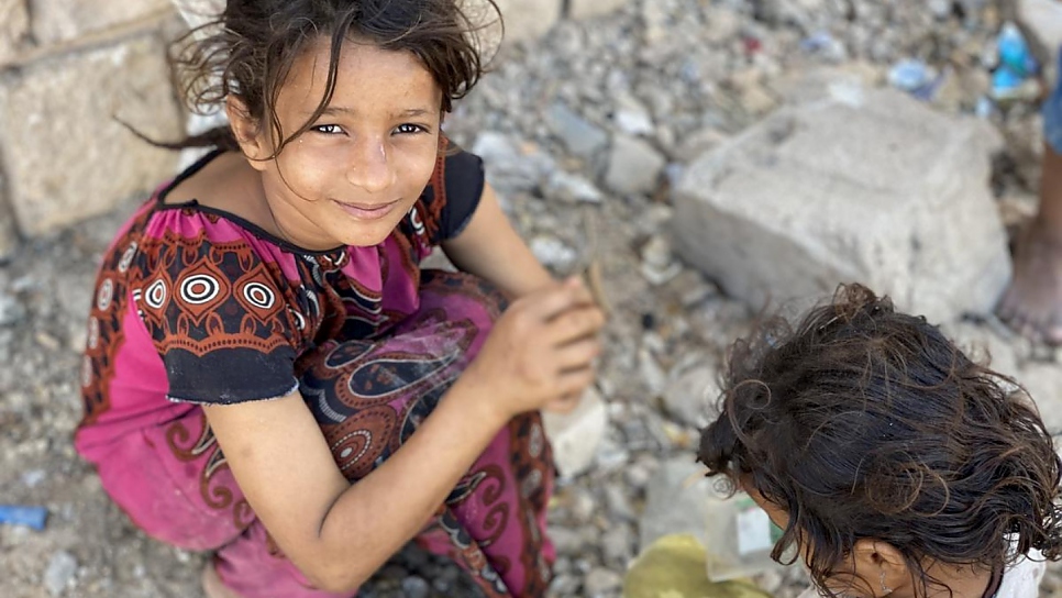 Ipteehal, 9 ans, joue avec sa soeur devant le bâtiment inachevé où elles vivent avec d'autres familles déplacées à Al Mukalla, au Yémen. 
