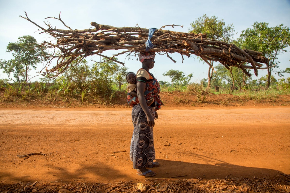 اللاجئة البوروندية هاسفاسيمانا، 25 عاماً، تحمل الحطب في طريق عودتها إلى المخيم. 