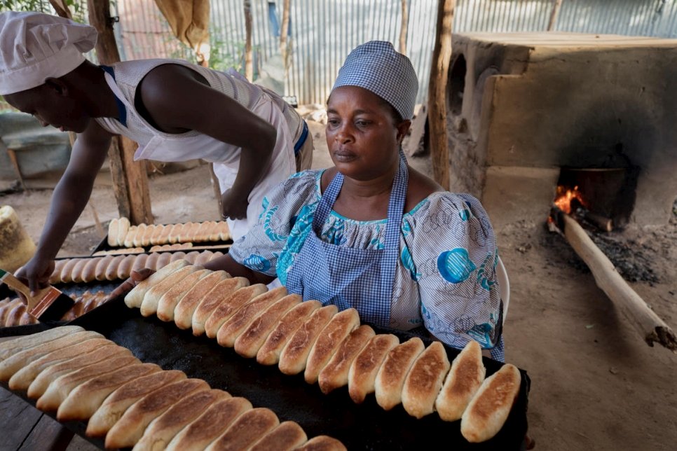 ماما سافي كيساسا، لاجئة وصاحبة مشروع صغير، تصنع الخبز الطازج مع أفراد العائلة.