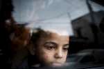 ينظر محمد، الطفل اللاجئ من سوريا، من نافذة في ضواحي بيروت، لبنان.