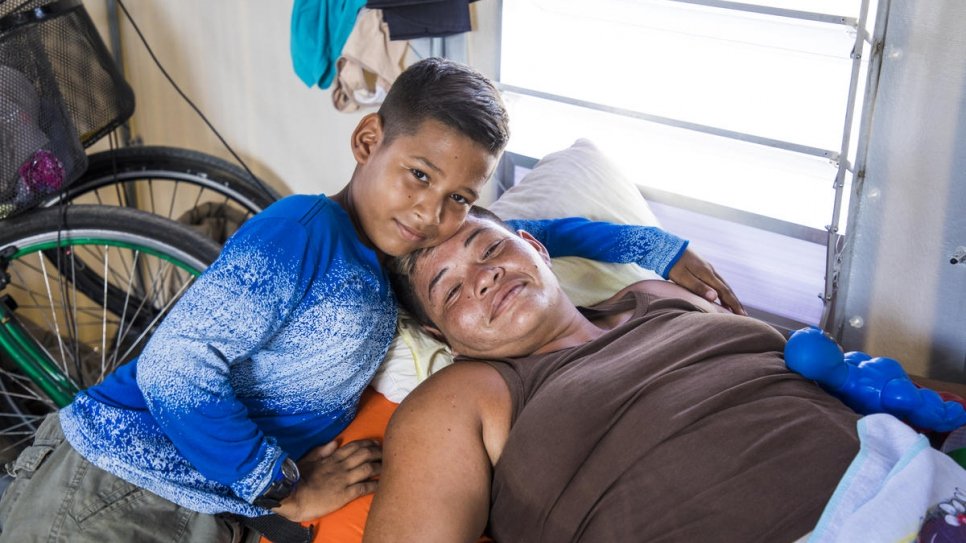 Moisés et sa mère dans la tente familiale de l'installation temporaire de Rondon 3 à Boa Vista, Brésil. 