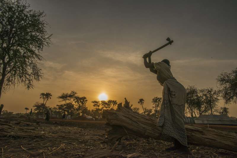 امرأة تقطع الحطب في مخيم دورو في جنوب السودان. تنقص إمدادات الحطب اللازم للطهي والتدفئة بدرجة كبيرة في المنطقة، وقد يكون الخروج للبحث عن الحطب خطراً على النساء والفتيات حيث يتعرضن للمهاجمة. 