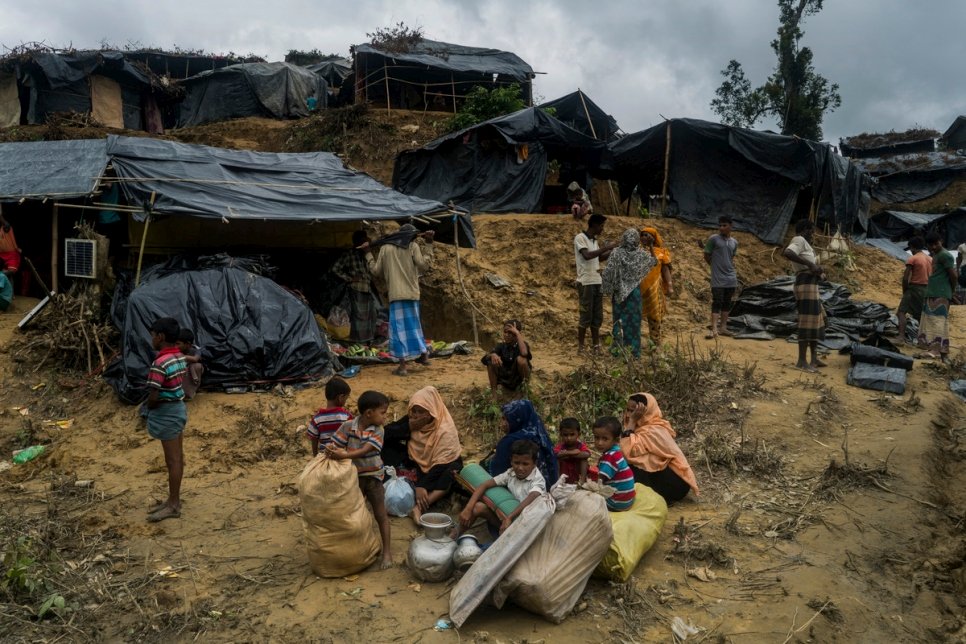 عائلة لاجئة من الروهينغا تنتظر  بينما تسعى لإيجاد مكان للعيش في مخيم عشوائي في ثانكالي، بنغلاديش.