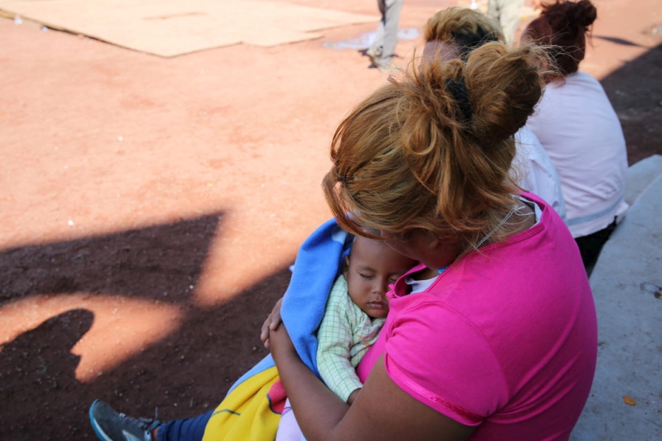 ميتزي تحمل ابنها لويس البالغ من العمر عاماً واحداً في مأوى مؤقت في ملعب خيسوس مارتينيز "باليلو" في مدينة مكسيكو.
