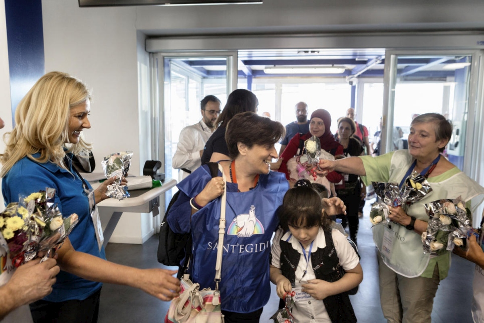 ماريا كوينتو، منسقة "الممرات الإنسانية" لدى سانت إجيديو، (في الوسط) مع الطفلة السورية هبة، البالغة من العمر 9 سنوات، بعد هبوطها في روما قادمة من لبنان.