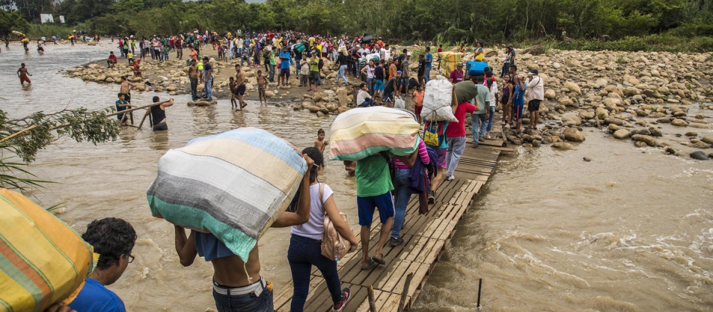 فنزويلون يعبرون الحدود للوصول إلى كولومبيا خلال ممرات موحلة تغطي ضفاف نهر تاتشيرا الذي يشكل الحدود بين فنزويلا وكولومبيا.
