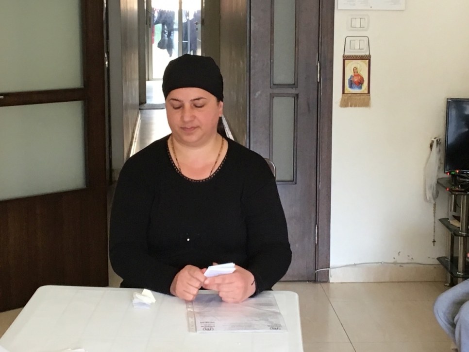 ميرنا يوسف تجلس في الشقة في بيروت حيث تهتم بأبنائها الأربعة، الذين تتراوح أعمارهم بين 12 و 22 عاماً، فضلاً عن حمويها العليلين.