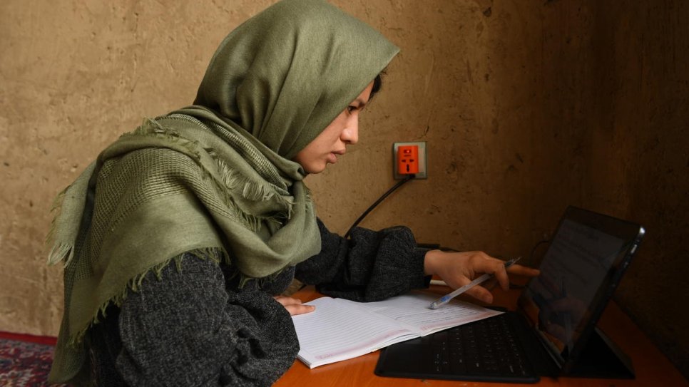 Kobra Yusufy, une rapatriée afghane de 27 ans, en train d'étudier chez elle à Kaboul, Afghanistan. 