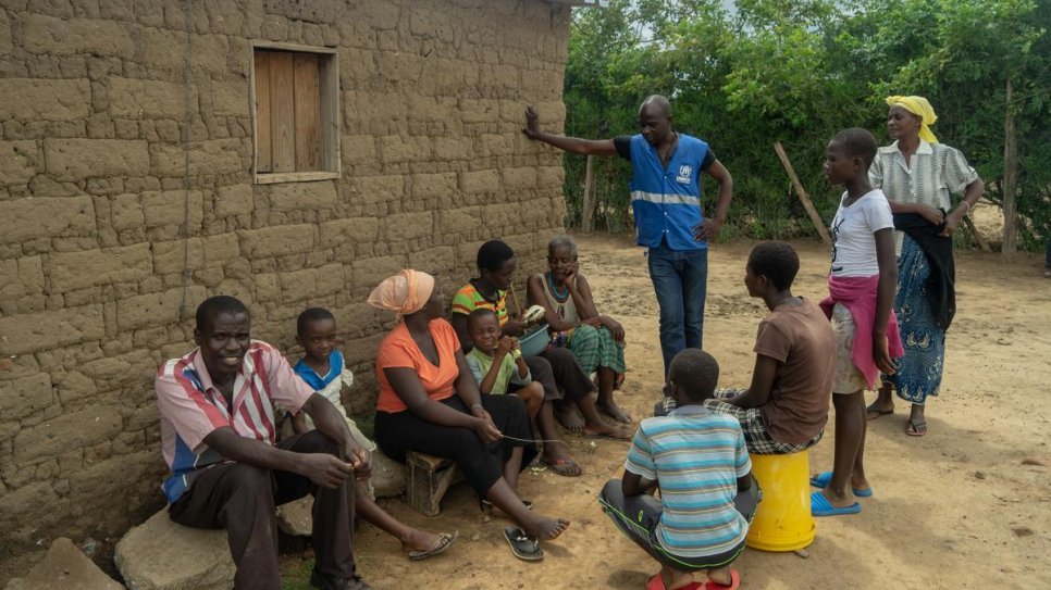 Un employé du HCR en conversation avec les membres de la famille de Magdalena Niragire au camp de réfugiés de Tongogara, Zimbabwe. 