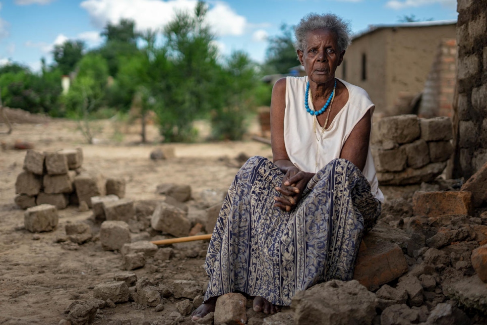 اللاجئة الرواندية ماغدالينا نيراجير تجلس أمام منزلها الذي تدمر بشكلٍ جزئي نتيجة الأمطار الغزيرة في مخيم تونغوغارا في زيمبابوي.