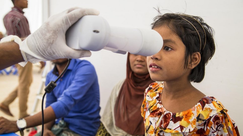 Une jeune réfugiée rohingya passe un scan de l'iris à l'aide d'un système de gestion de l'identité biométrique au camp de réfugiés de Nayapara, à Teknaf, lors de l'exercice conjoint de vérification mené par le gouvernement du Bangladesh et le HCR en 2018. 