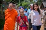 Le Vénérable Vudhijaya Vajiramedhi marche au côté d'un réfugié âgé et de Praya Lundberg, Ambassadrice de bonne volonté du HCR en Thaïlande, lors de sa visite au refuge temporaire Tham Hin en Thaïlande. 