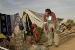 Julien Clerc en compagnie de réfugiées soudanaises dans le camp de Kounoungo, dans l'est du Tchad, mars 2004. 