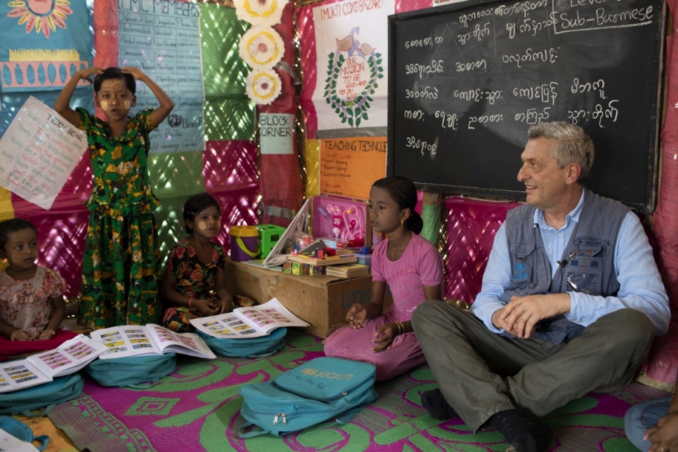 Myshara (en rose), une réfugiée Rohingya âgée de 13 ans, et le chef du HCR, Filippo Grandi, sont assis dans une salle d'école du camp de Kutupalong, au Bangladesh. 