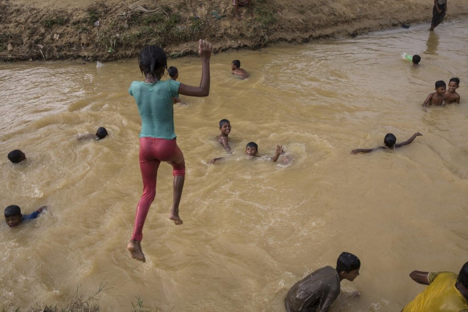 Un enfant saute dans un ruisseau boueux, après de fortes pluies au camp de réfugiés de Balukhali.  