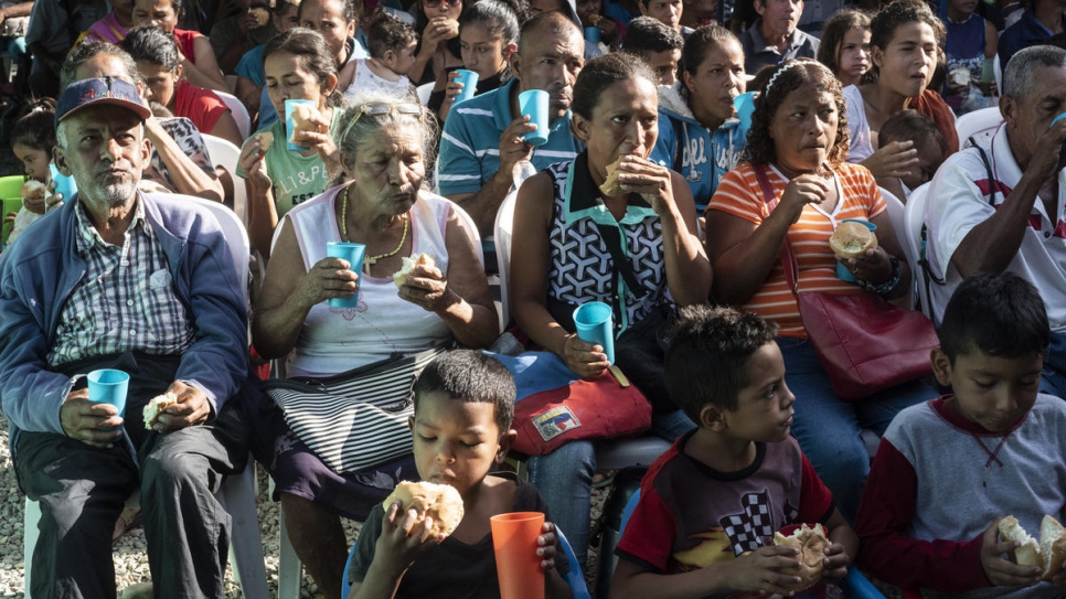 Des réfugiés et des migrants vénézuéliens reçoivent du pain à la Casa de Paso Divina Providencia, un centre de distribution de vivres géré par l'Église catholique et soutenu par le HCR à Cúcuta, en Colombie. 