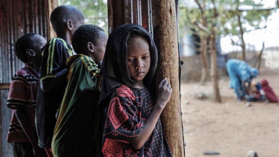 A Somali refugee girl stands next to her brothers in a World Vision's school used as a temporary shelter in Bur Amino, Ethiopia. 