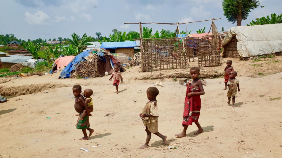 Des enfants traversent une installation de fortune qui accueille des membres déplacés de la communauté indigène Mbuti dans le quartier de Ruvangira à Oicha, dans la province du Nord-Kivu.