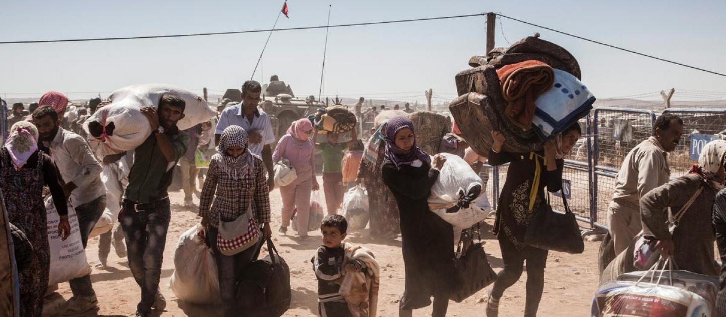 لاجئون سوريون أكراد يعبرون إلى تركيا بالقرب من بلدة عين العرب (كوباني) في سوريا، في صورة أرشيفية تعود لشهر سبتمبر 2014 