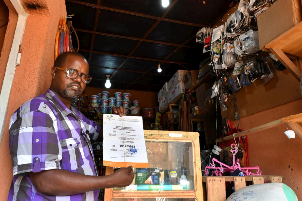 Dans son magasin de détail à Kigali au Rwanda, Ali Abdi montre sa licence d'exploitation.  