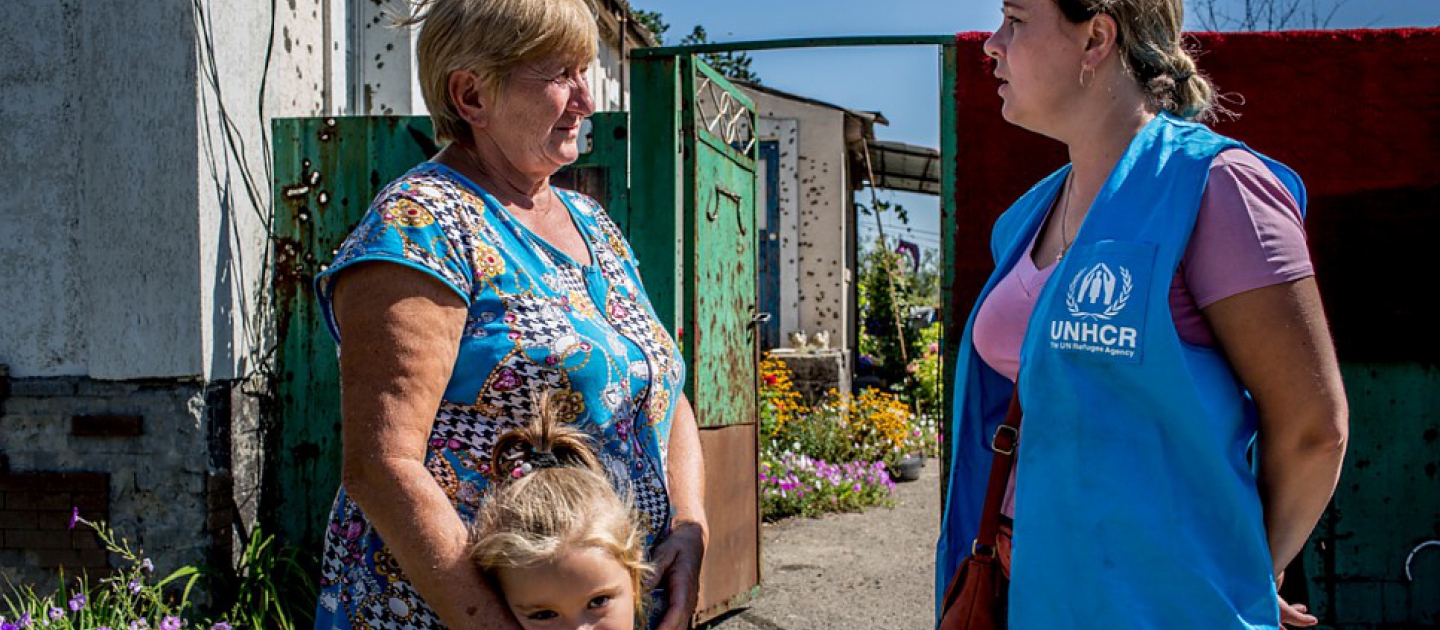 موظفة في المفوضية تتحدث مع أحد السكان المحليين الذين تدمر منزلهم في القتال الذي دار عام 2014 في منطقة لوهانسك، شرق أوكرانيا