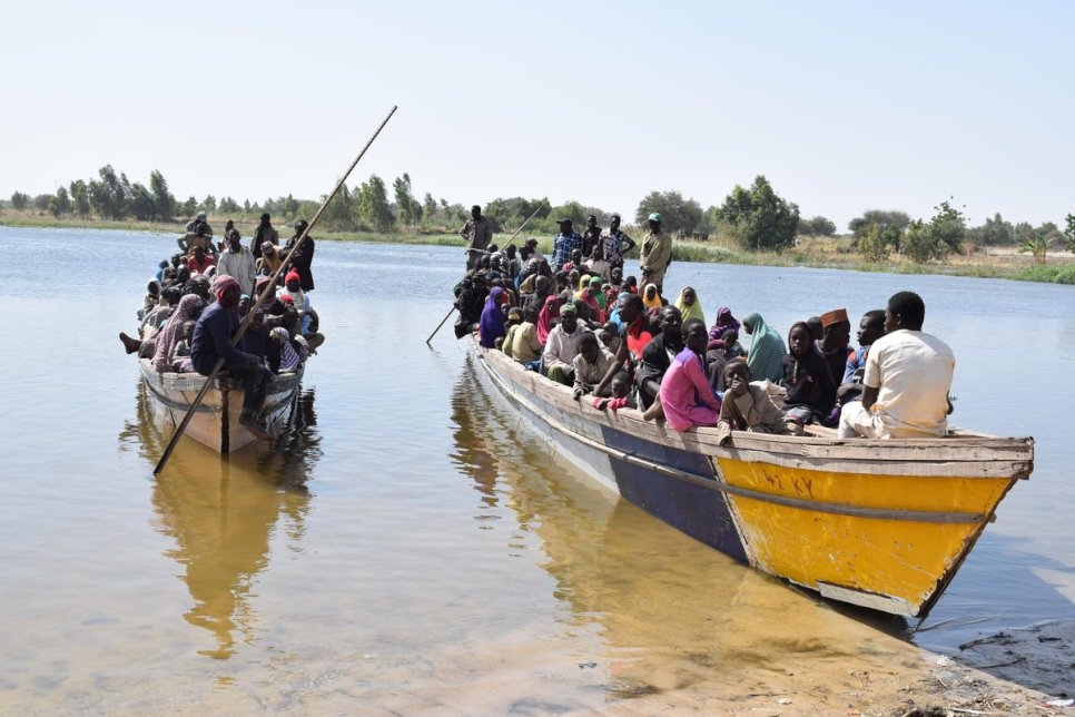 Des réfugiés entassés dans des canots motorisés arrivent à Ngouboua, au Tchad, après avoir fui les violences dans le Sahel et le bassin du lac Tchad.  