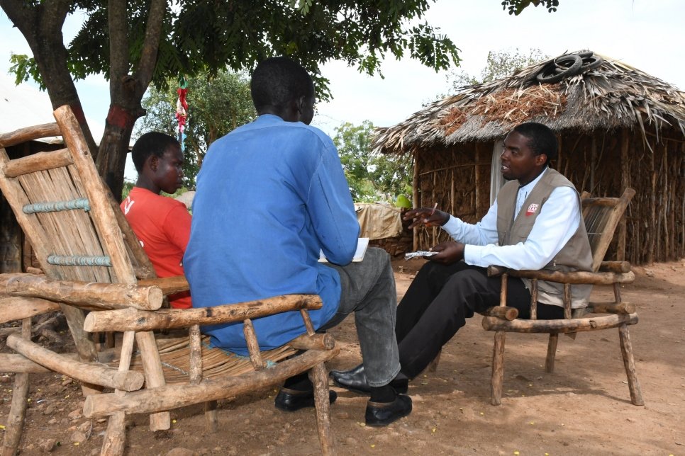 Jedah Twebaze (à droite), infirmier ougandais spécialiste du VIH, discute avec Inga Viola (à gauche) et Rufas Taban, réfugiés sud-soudanais, dans l'installation de réfugiés d'Imvepi.