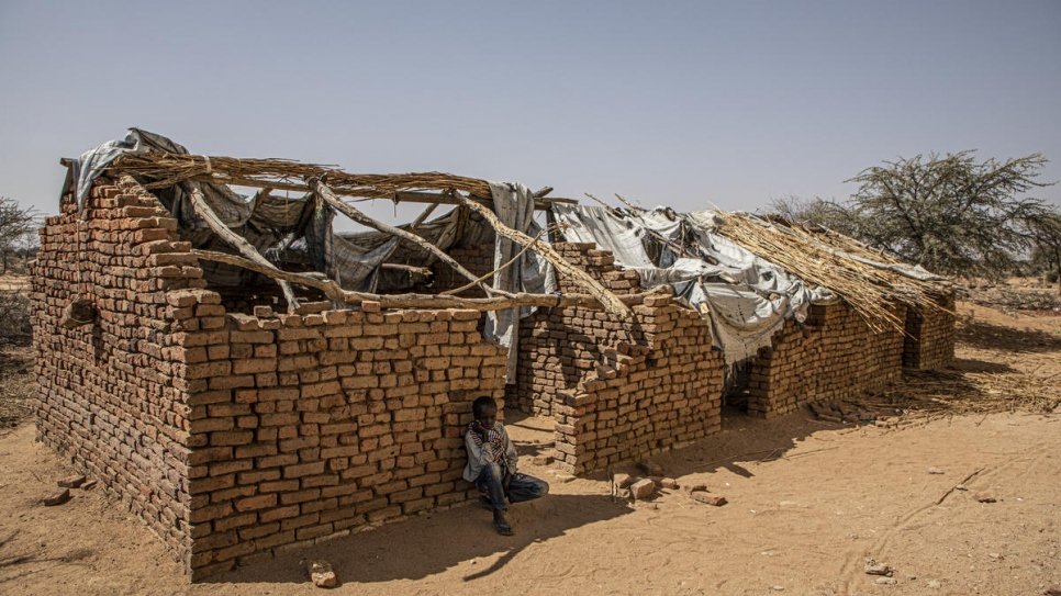 Un jeune garçon soudanais est assis à l'ombre d'un bâtiment scolaire désaffecté dans le village de Dady près de Kabkabiya, au Darfour du Nord, au Soudan. 