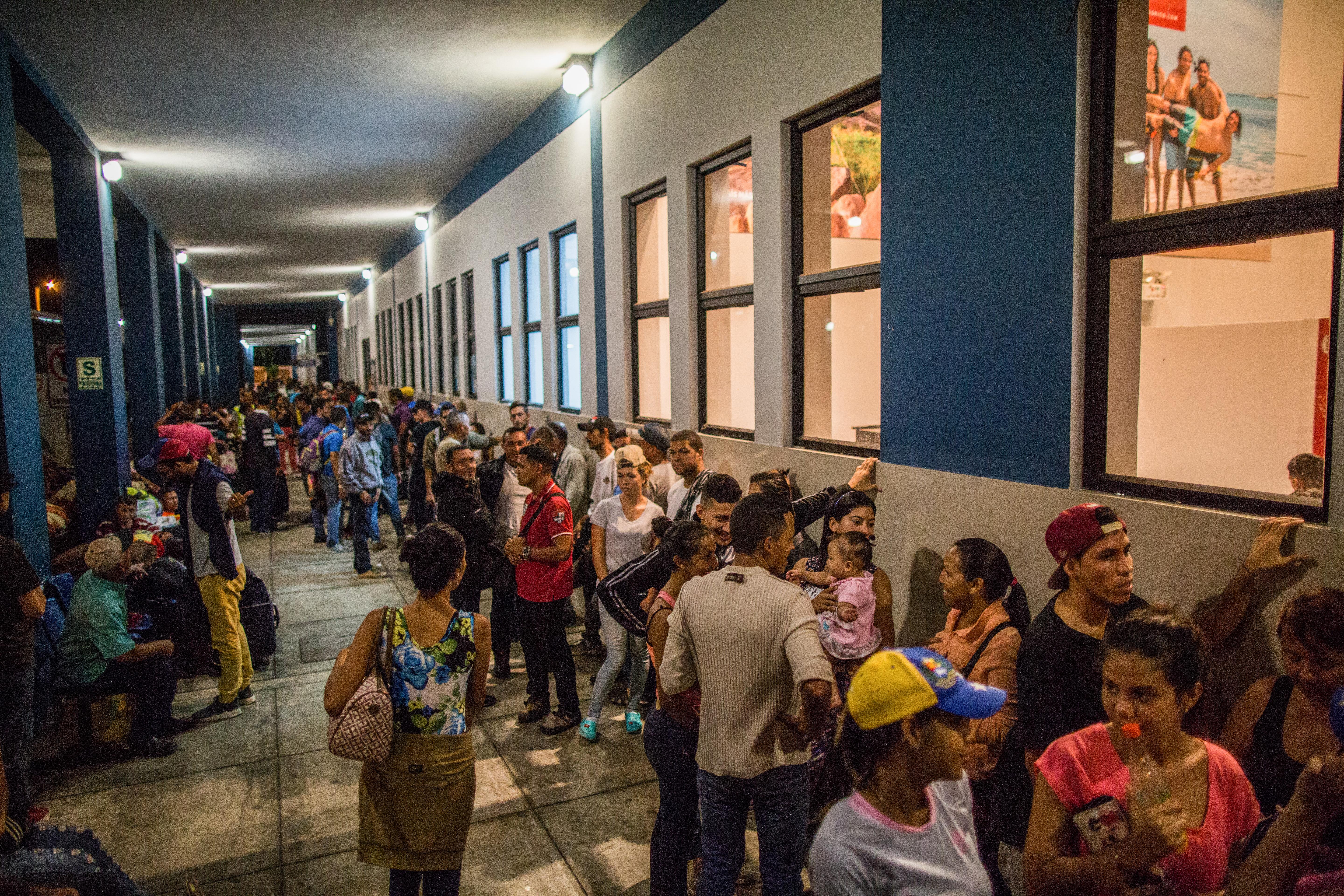 Venezuelans waiting and queuing inside a building.