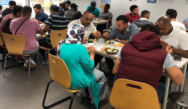 A group of people sit together and share a meal