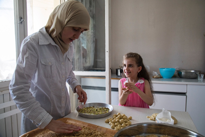 A woman and a girl baking.