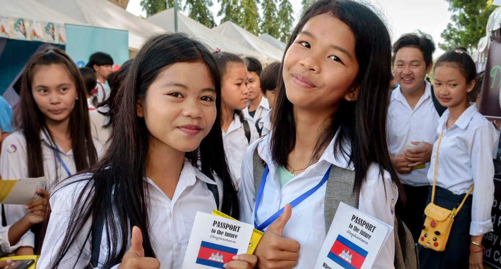 Two student girls attending a career fair face the camera 
