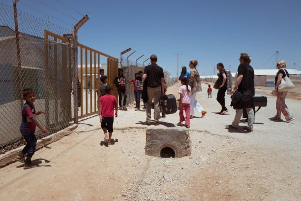 A group of people entering through a fence