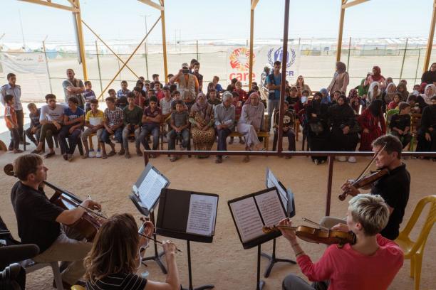 Musicians perform in front of a group of people