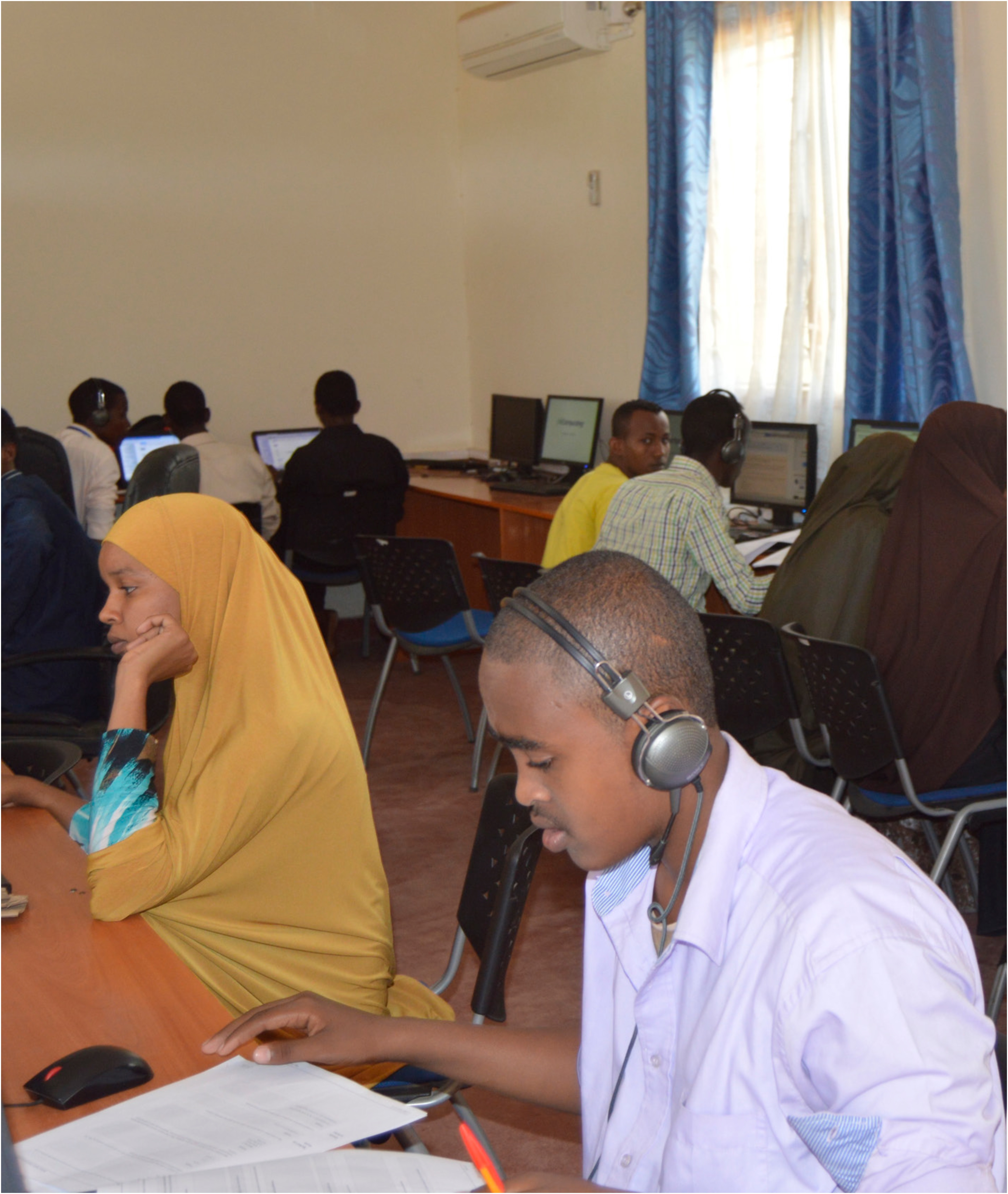 Young people sit in a classroom with computers