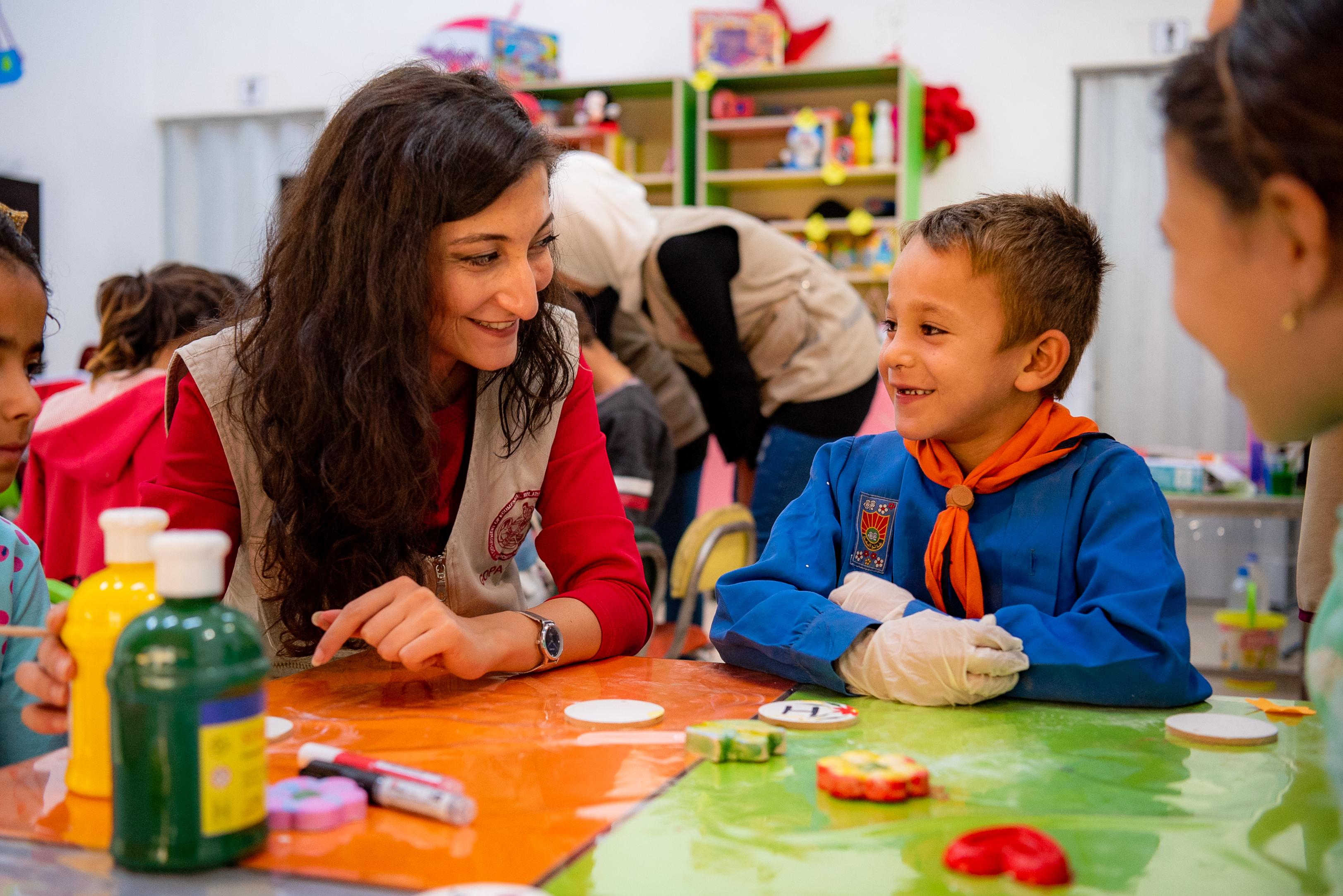 Children with their teacher do painting activities