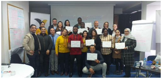 People facing the camera standing holding a certificate. 