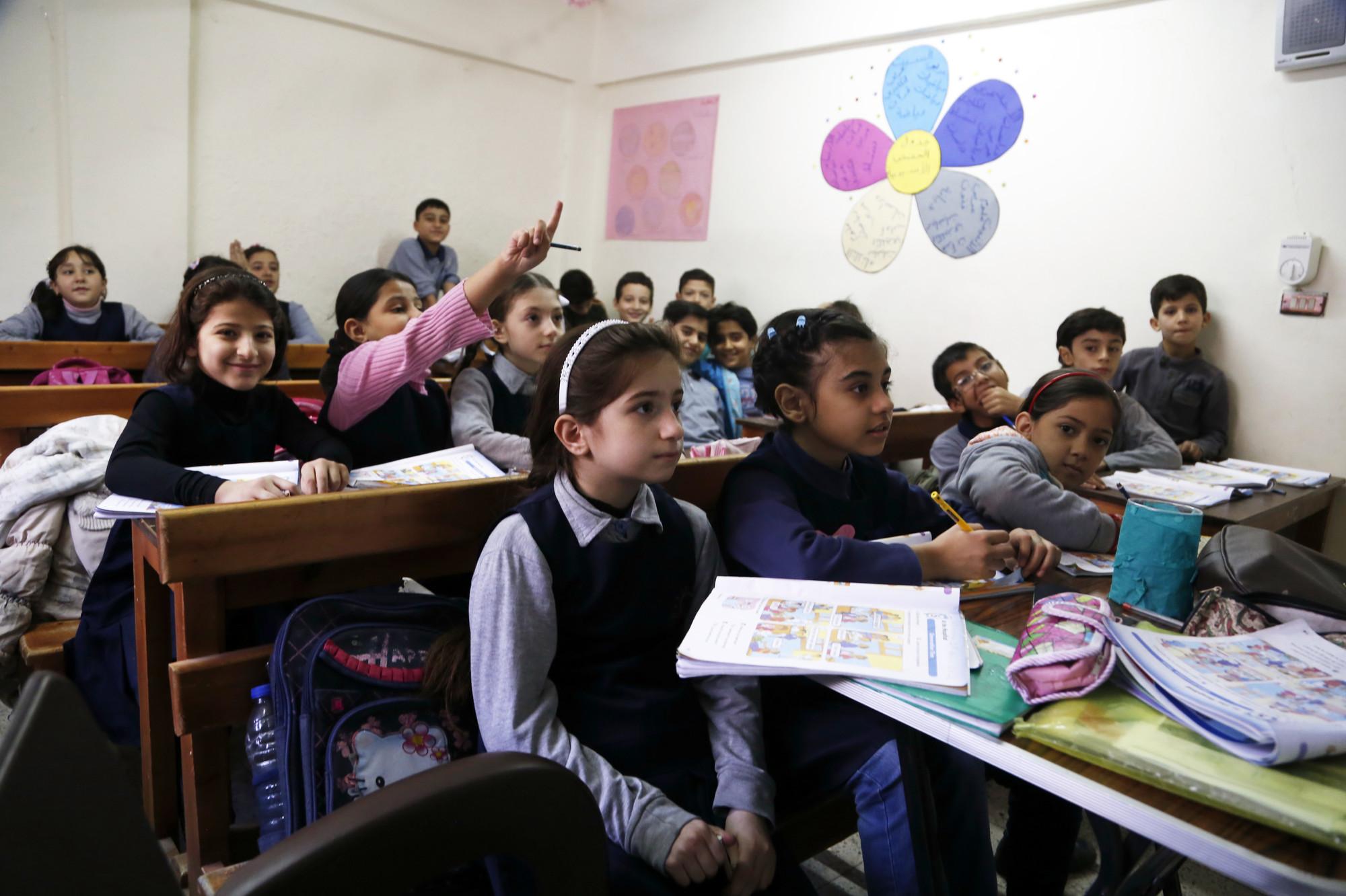 Kids in a classroom seated. 