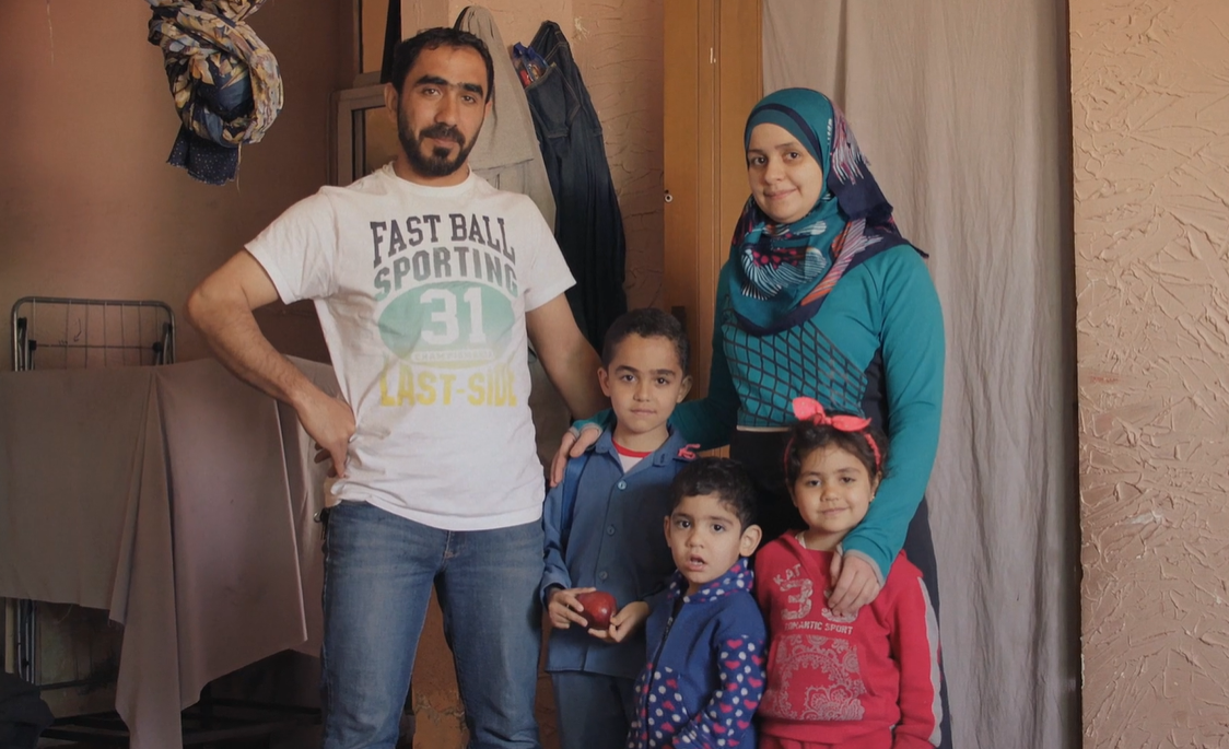 Family smiling and looking at the camera.