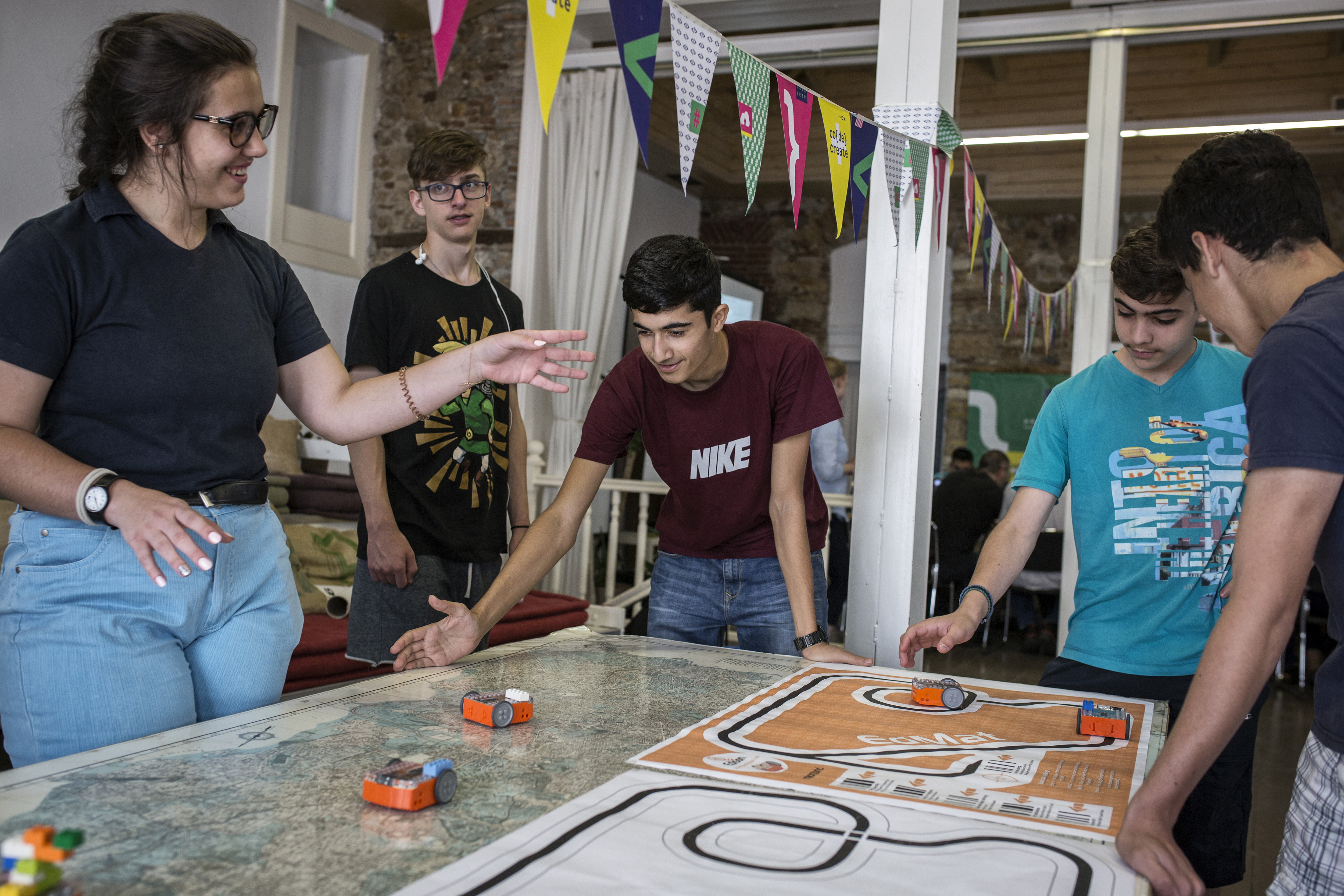 A group of youths work together to make toy cars move.