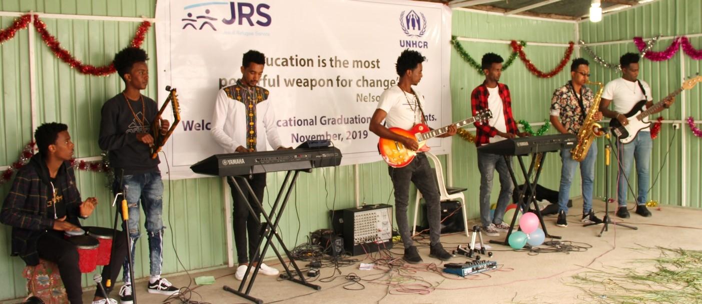 Four people on a stage playing musical instruments