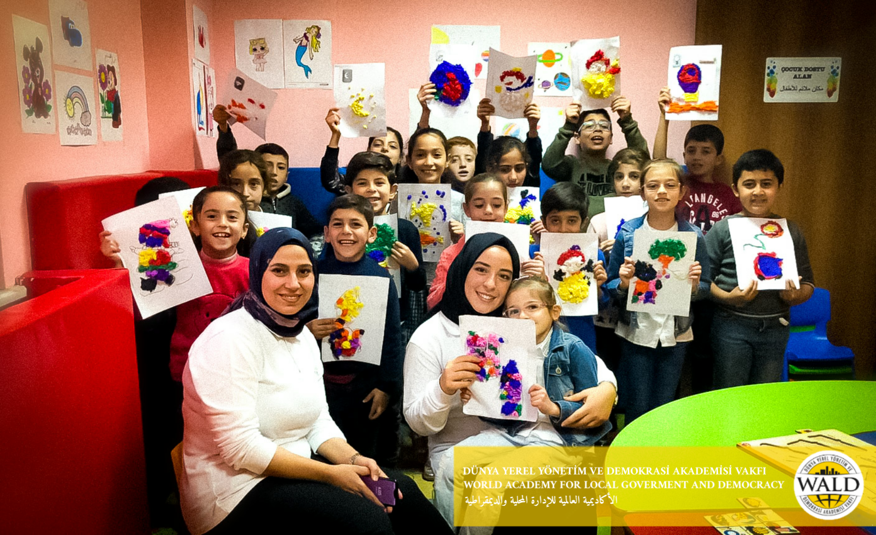 Woman and kids holding images facing the camera.