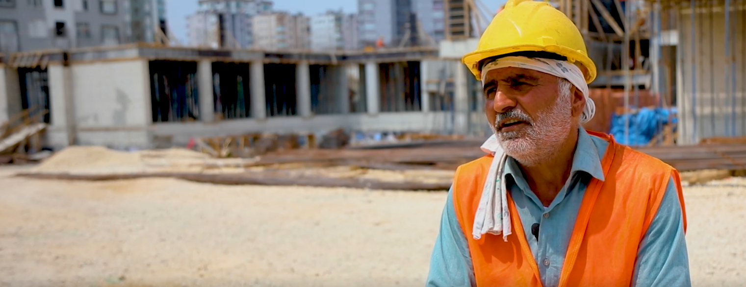 Construction worker in front school construction site