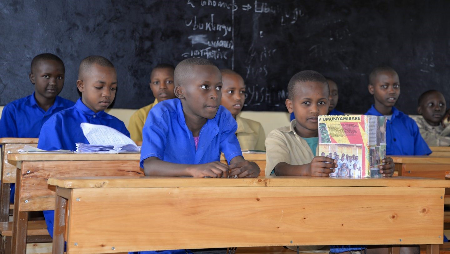 Children sit at desks in a classroom 