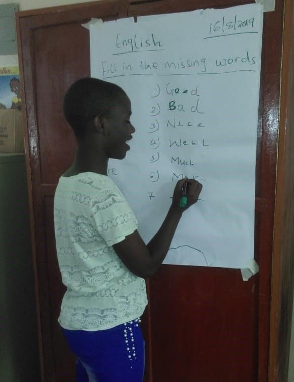 Young girl writing on a white paper board.